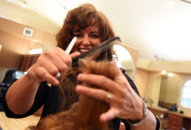 Gwen Arguello smiles as she cuts the hair of Sandee Childs, on Wednesday at Gwen's Salone Cottonwood Square, 2317 W. 17th St., in Greeley. Arguello's new location for the salon now also includes a barber shop, massage area, and several other new features.