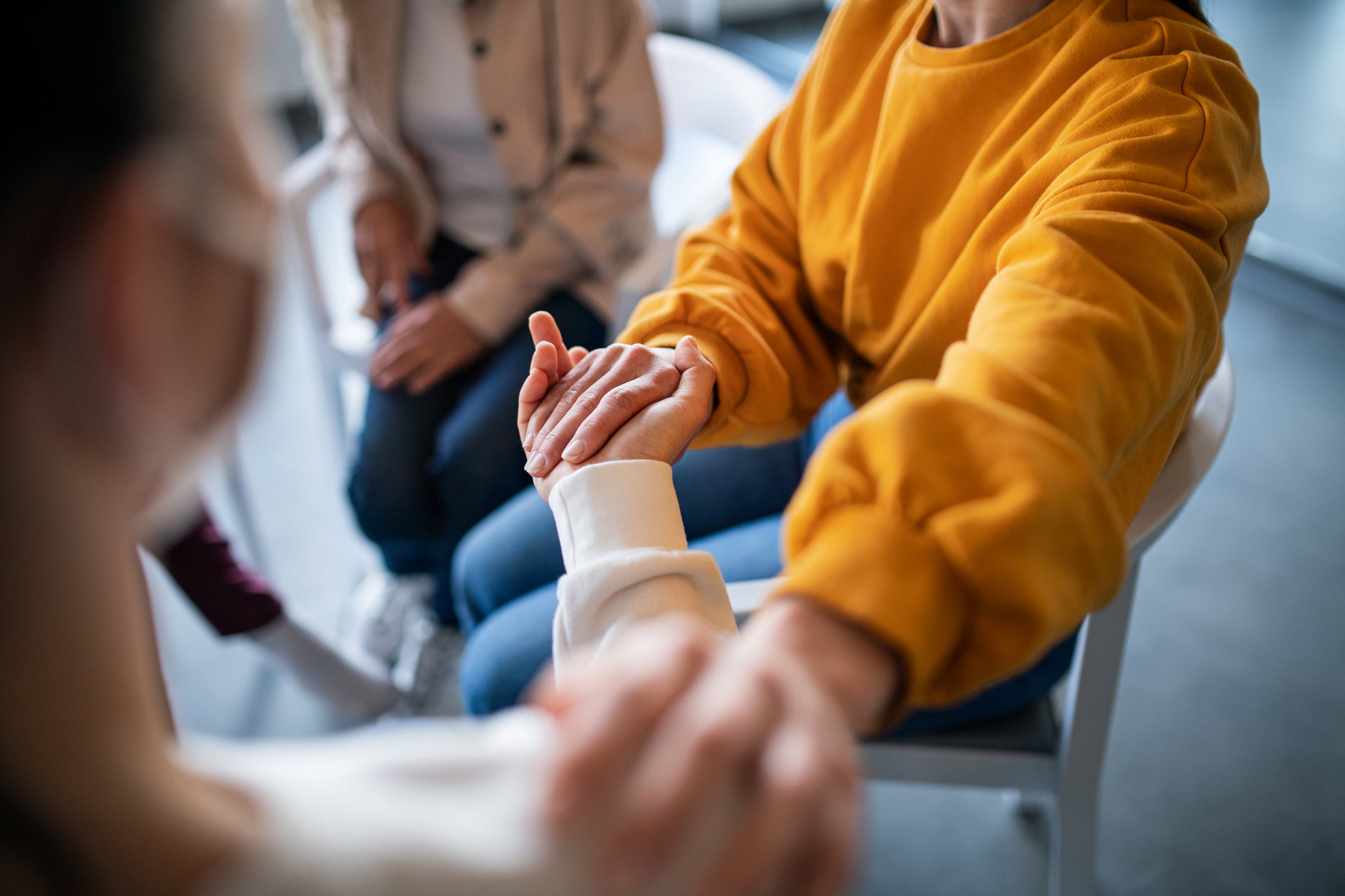 Unrecognizable depressed woman on group therapy, counselling concept.