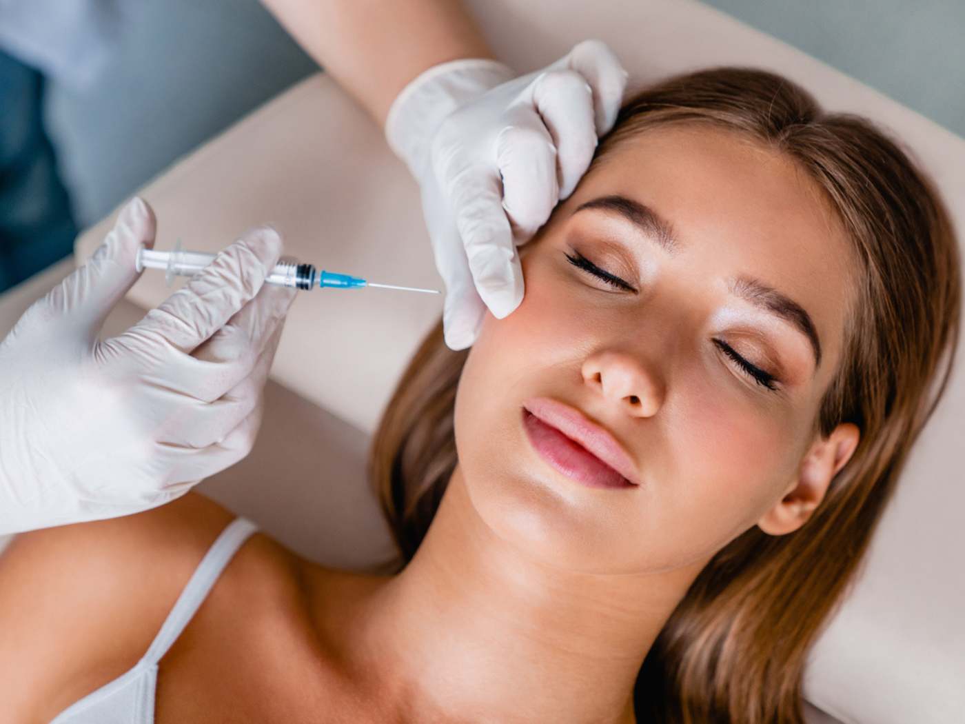 Woman receiving a facial injection from a doctor