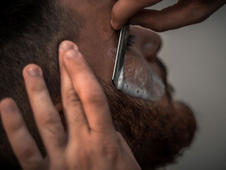 Barber shaving a beard Image Credit: Pexels