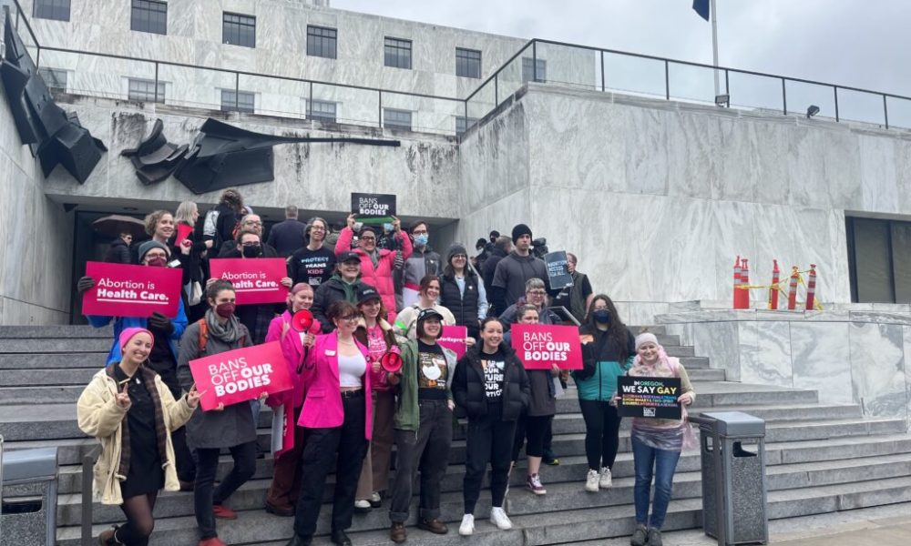 Supporters of an Oregon bill to expand access to abortion and gender-affirming care pos outside the state Capitol after a rally and ahead of the bill’s first hearing. (Julia Shumway/Oregon Capital Chronicle)