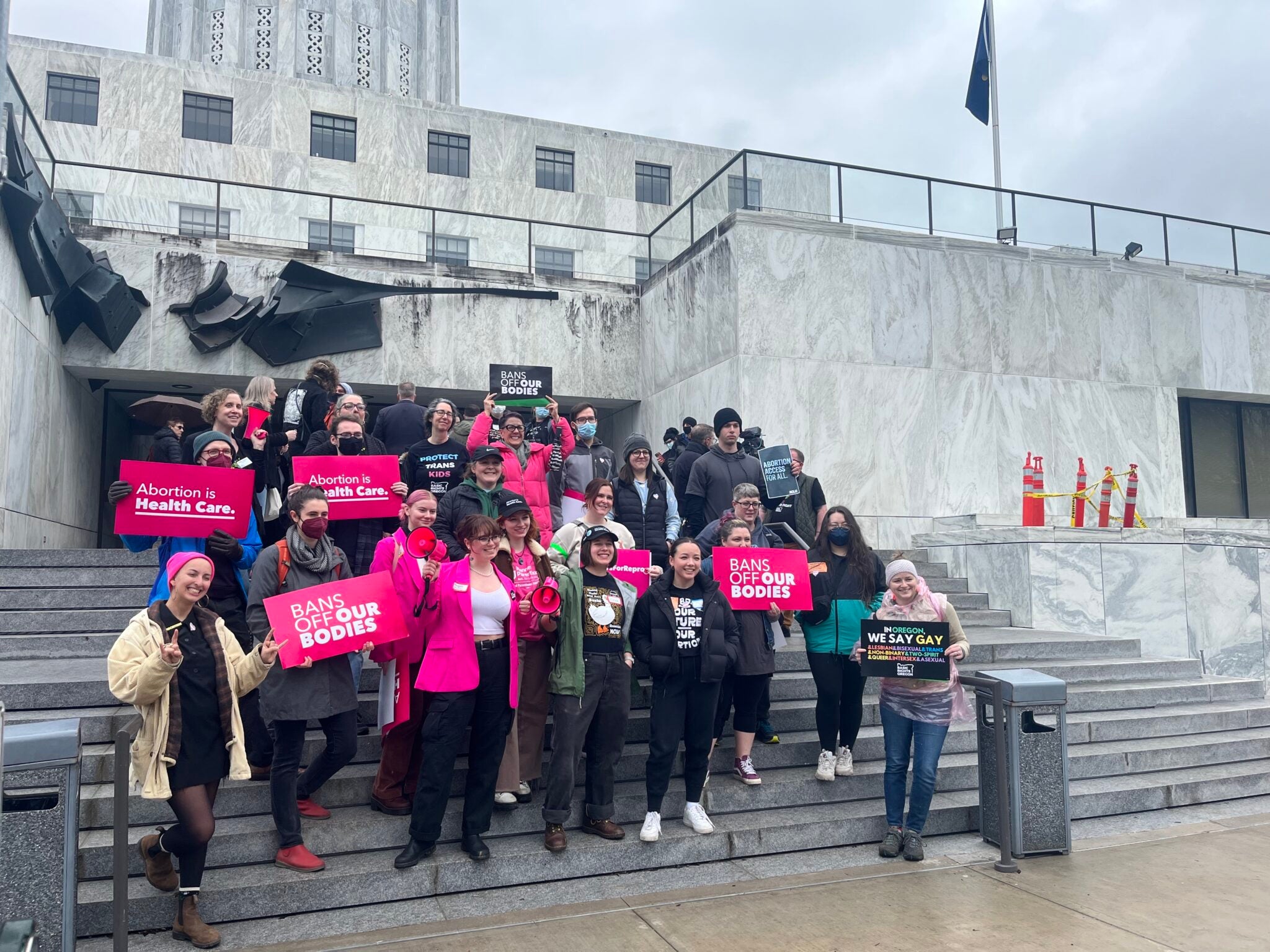 Supporters of an Oregon bill to expand access to abortion and gender-affirming care posed outside the state Capitol in April after a rally and ahead of the bill’s first hearing. (Julia Shumway/Oregon Capital Chronicle)