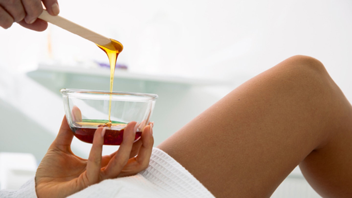 Beautician prepares wax for a beauty treatment.