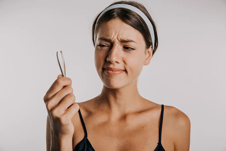 a woman holding a tweezer